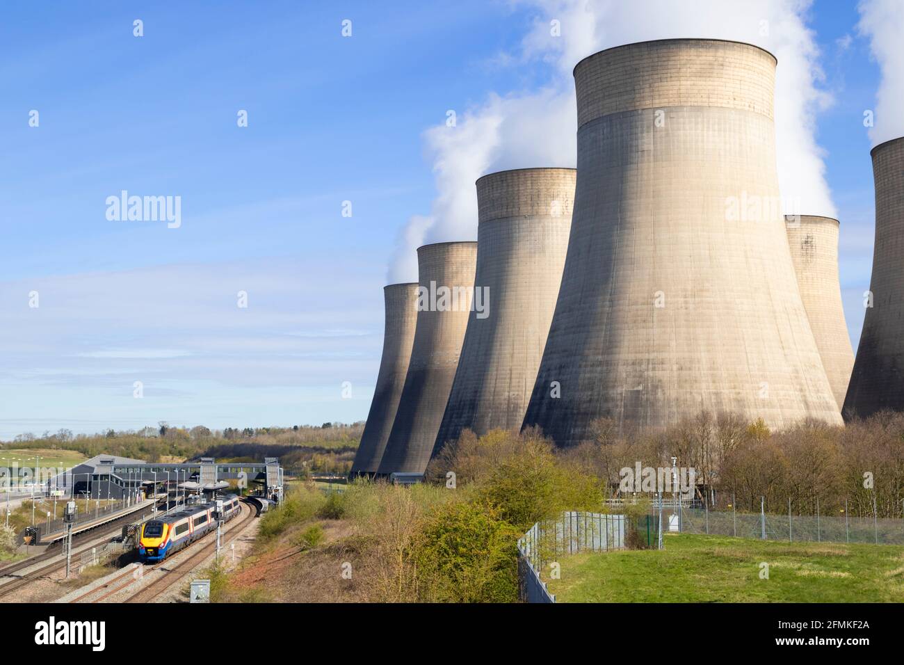Kohlekraftwerk Ratcliffe-on-Soar mit Dampf aus Kühltürmen und einem Zug am Parkway-Bahnhof Ratcliffe auf dem Aufstieg Nottinghamshire England Stockfoto