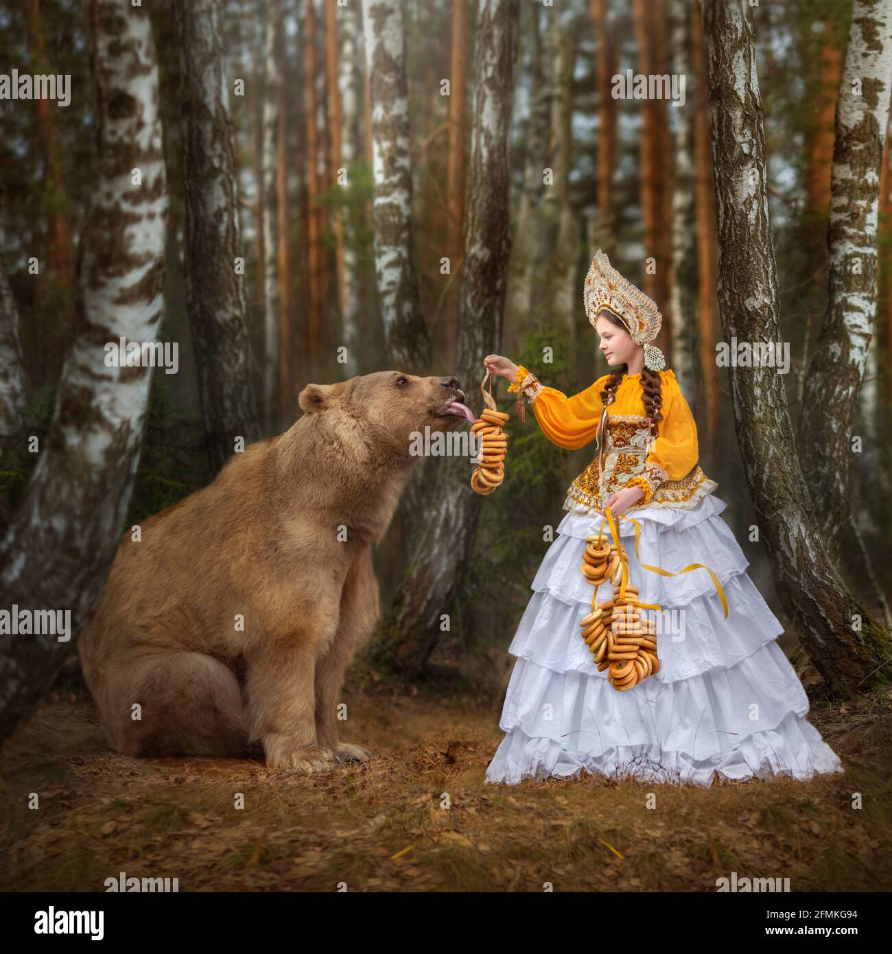 Ein junges Mädchen füttert Stepan einige süße Leckereien. MOSKAU, RUSSLAND: TREFFEN SIE DEN echten Bären, der von seiner Mutter verlassen und von Menschen aufgezogen wurde, die jetzt eine Flouri haben Stockfoto