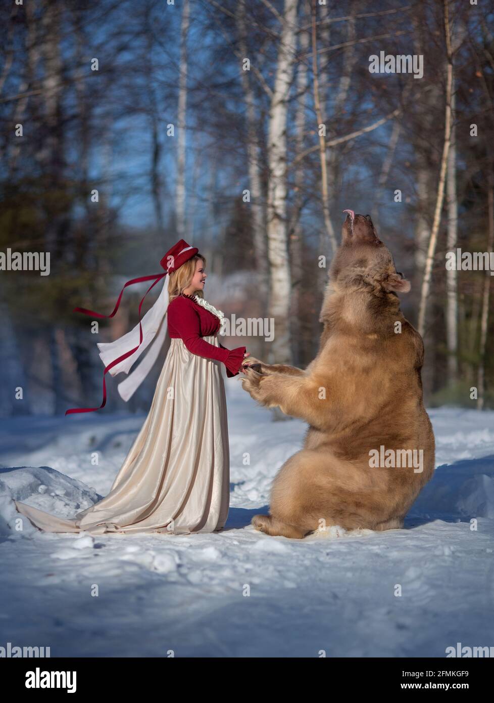 Stepan hält die Hände mit diesem Modell in einem verschneiten Wald. MOSKAU, RUSSLAND: TREFFEN SIE DEN echten Bären, der von seiner Mutter verlassen und von Menschen aufgezogen wurde, die jetzt eine haben Stockfoto