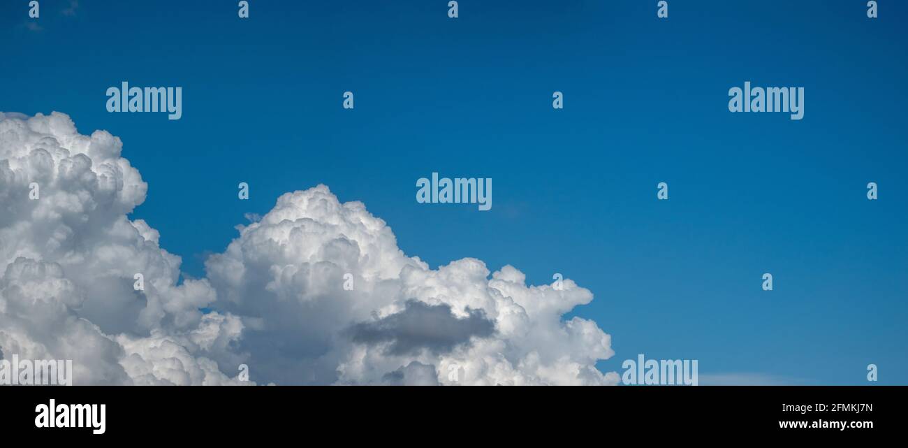 Panoramalandschaft mit blauem Himmel und auftauchenden weißen Wolken Unten links vom Schuss Stockfoto