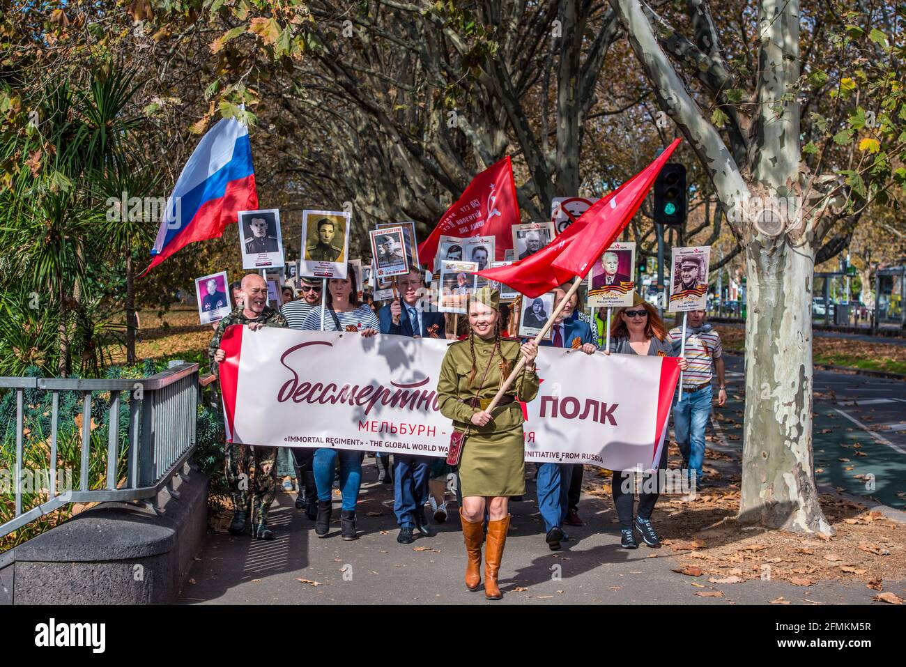 Melbourne, Australien, 09/05/2021, Teilnehmer mit Siegessiegefahnen, russischen Flaggen und sowjetischen Flaggen marschieren entlang der St Kilda Road, angeführt von einer Frau in Militäruniform. „Unsterbliches Regiment“, ein Teil der Feier zum Victory Day am 9. Mai im Memorial „Shrine of Remembrance“ in Melbourne. Der marsch des Unsterblichen Regiments wurde vom russischen Botschafter in Australien und einem ersten Sekretär der russischen Botschaft besucht und ist Teil einer weltweiten Siegesfeier. Menschen mit Fahnen, Transparenten und vor allem Fotos ihrer Familienmitglieder, die im Weltkrieg 2 kämpften, marschierten durch die Straßen von Stockfoto