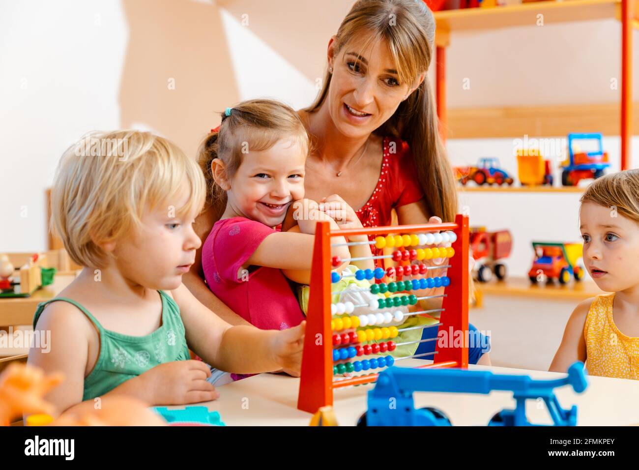 Vorschullehrer, der mit den Kindern spielt Stockfoto