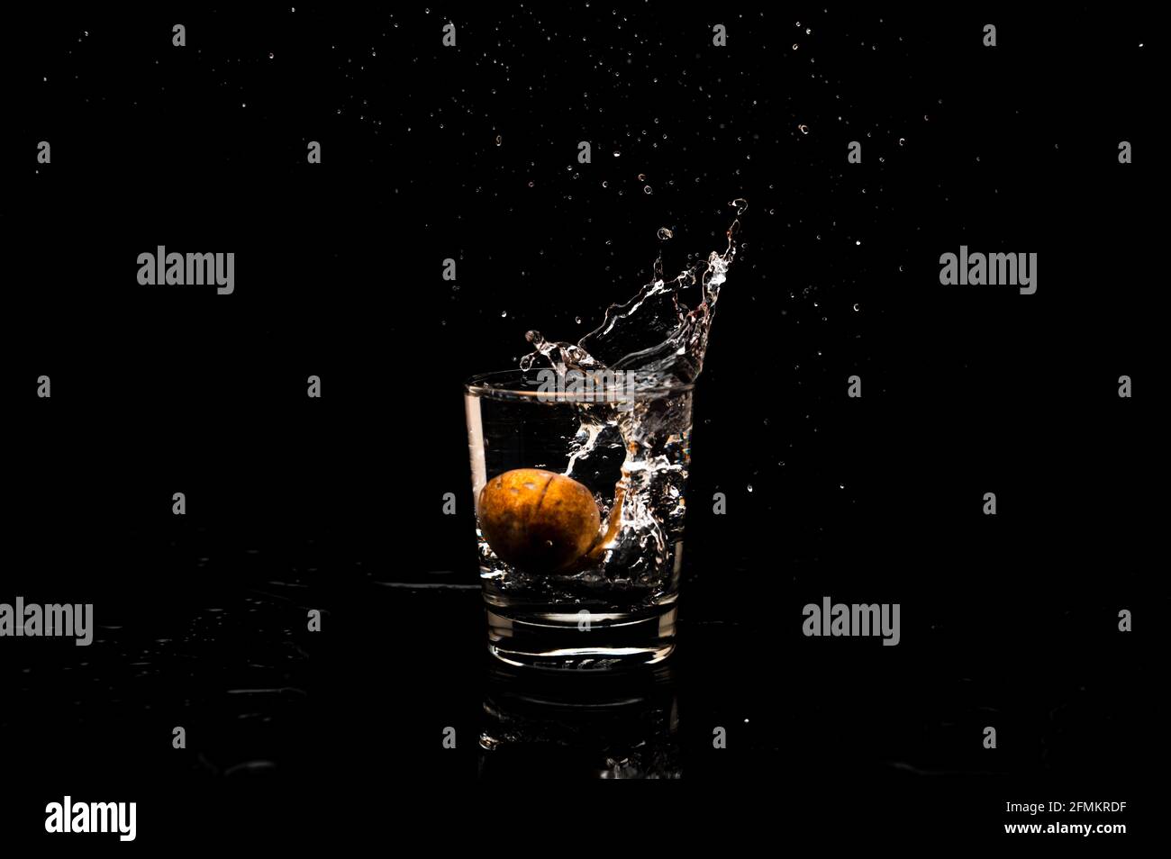 Hochauflösende Spritzgefrierbewegung aus einem sauberen Glas Wasser mit Tropfenbildung, isoliert auf schwarzem Hintergrund Stockfoto