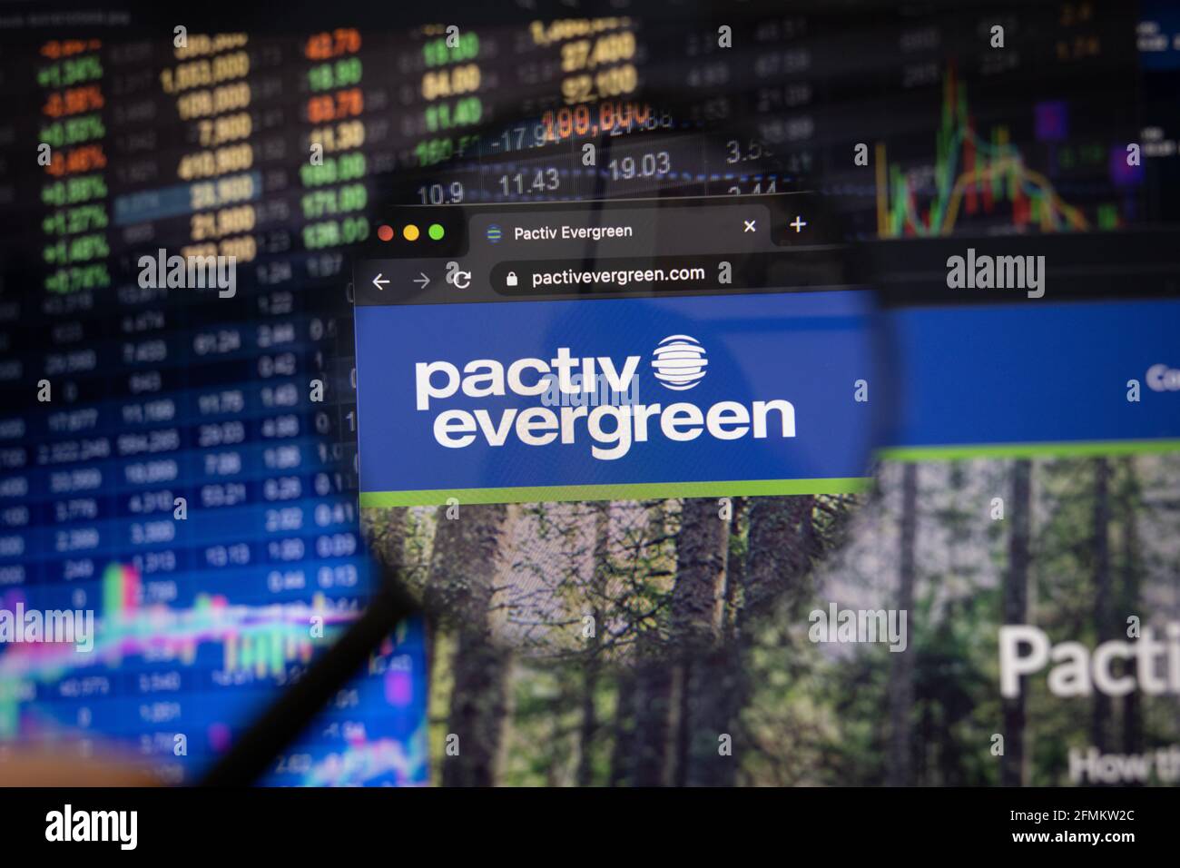Pactiv Evergreen Firmenlogo auf einer Website mit verschwommenen Börsenentwicklungen im Hintergrund, gesehen auf einem Computerbildschirm Stockfoto