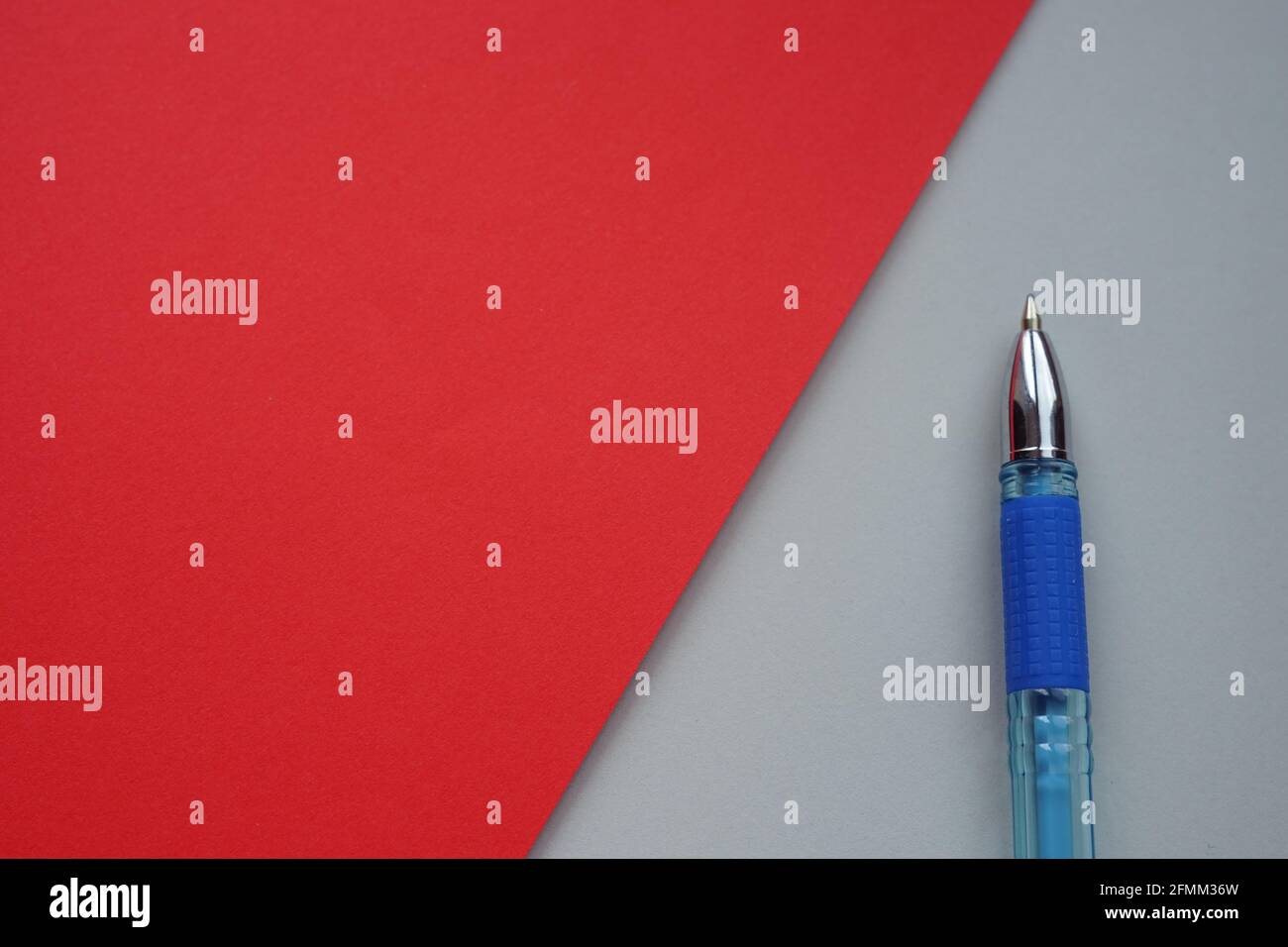 Blauer Kugelschreiber auf grau mit rotem Papier, Kopierplatz Stockfoto