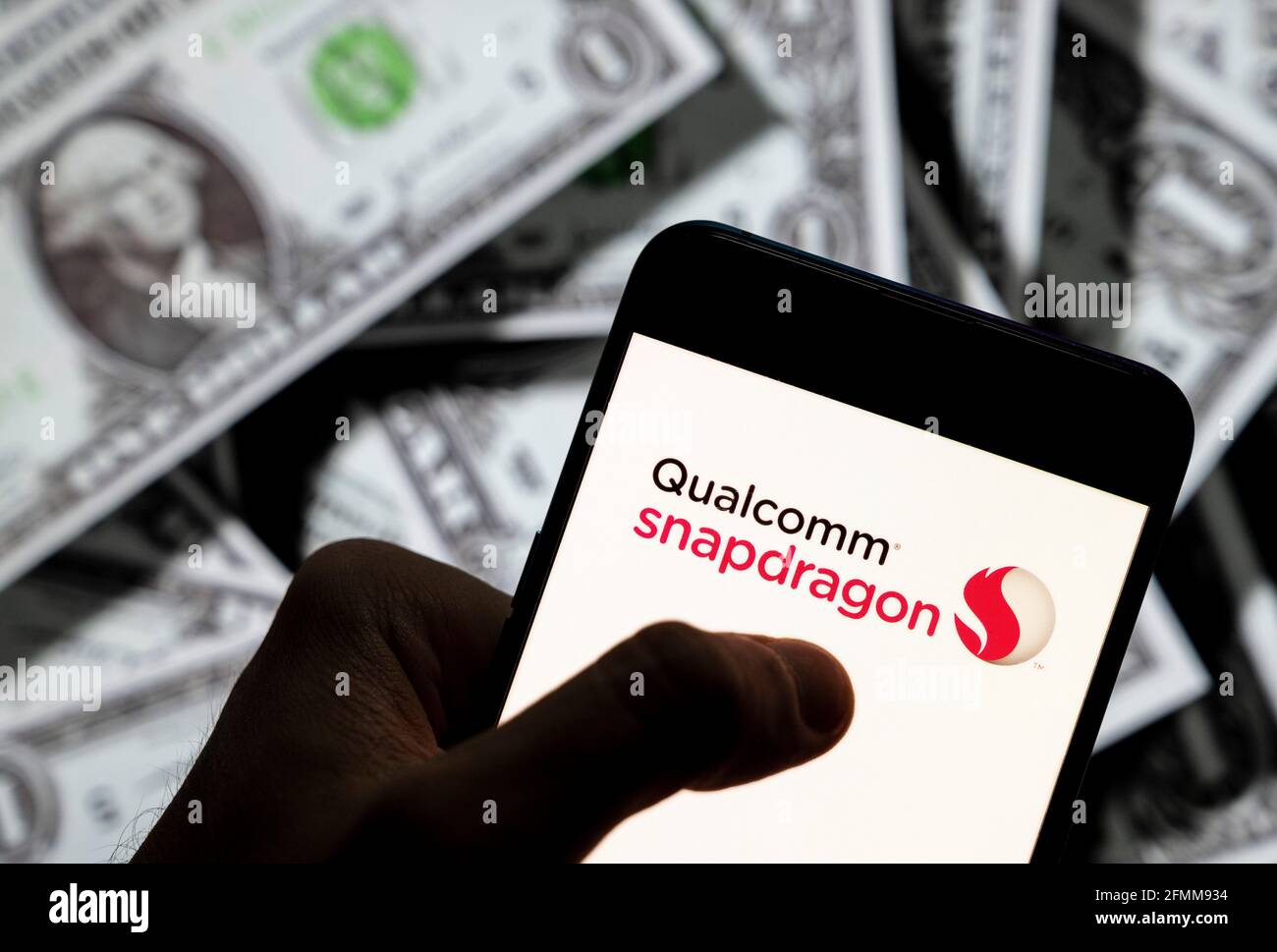 China. April 2021. In dieser Abbildung zeigt das mobile System auf einem Chip (SoC) von Qualcomm, das Qualcomm Snapdragon-Logo, das auf einem Smartphone mit US-Dollar-Währung im Hintergrund angezeigt wird. (Foto von Budrul Chukrut/SOPA Images/Sipa USA) Quelle: SIPA USA/Alamy Live News Stockfoto