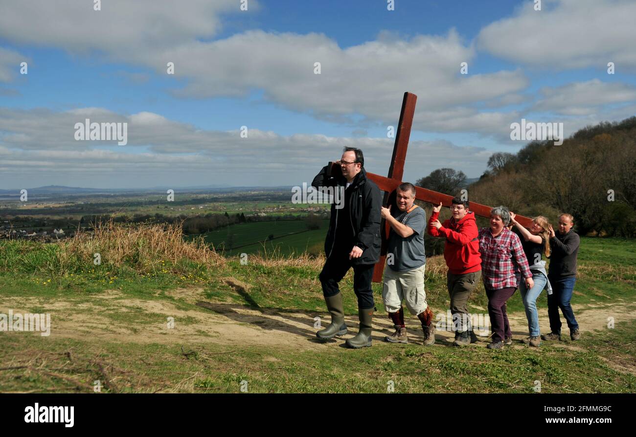 Am Karfreitag vor dem Ostersonntag ein Holzkreuz auf den Cam Peak tragen, bei einem Spaziergang von Witness, Gloucestershire Stockfoto