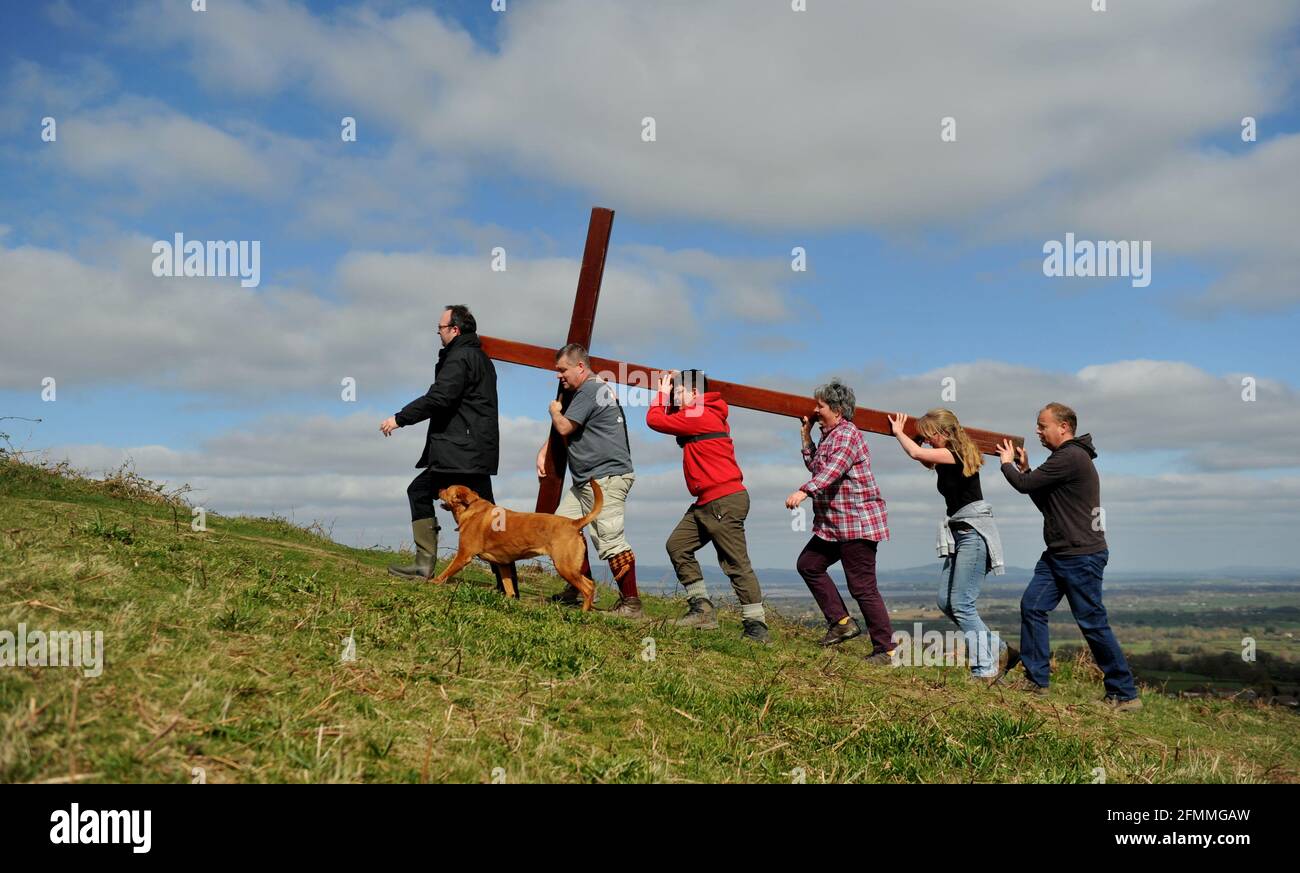 Am Karfreitag vor dem Ostersonntag ein Holzkreuz auf den Cam Peak tragen, bei einem Spaziergang von Witness, Gloucestershire Stockfoto