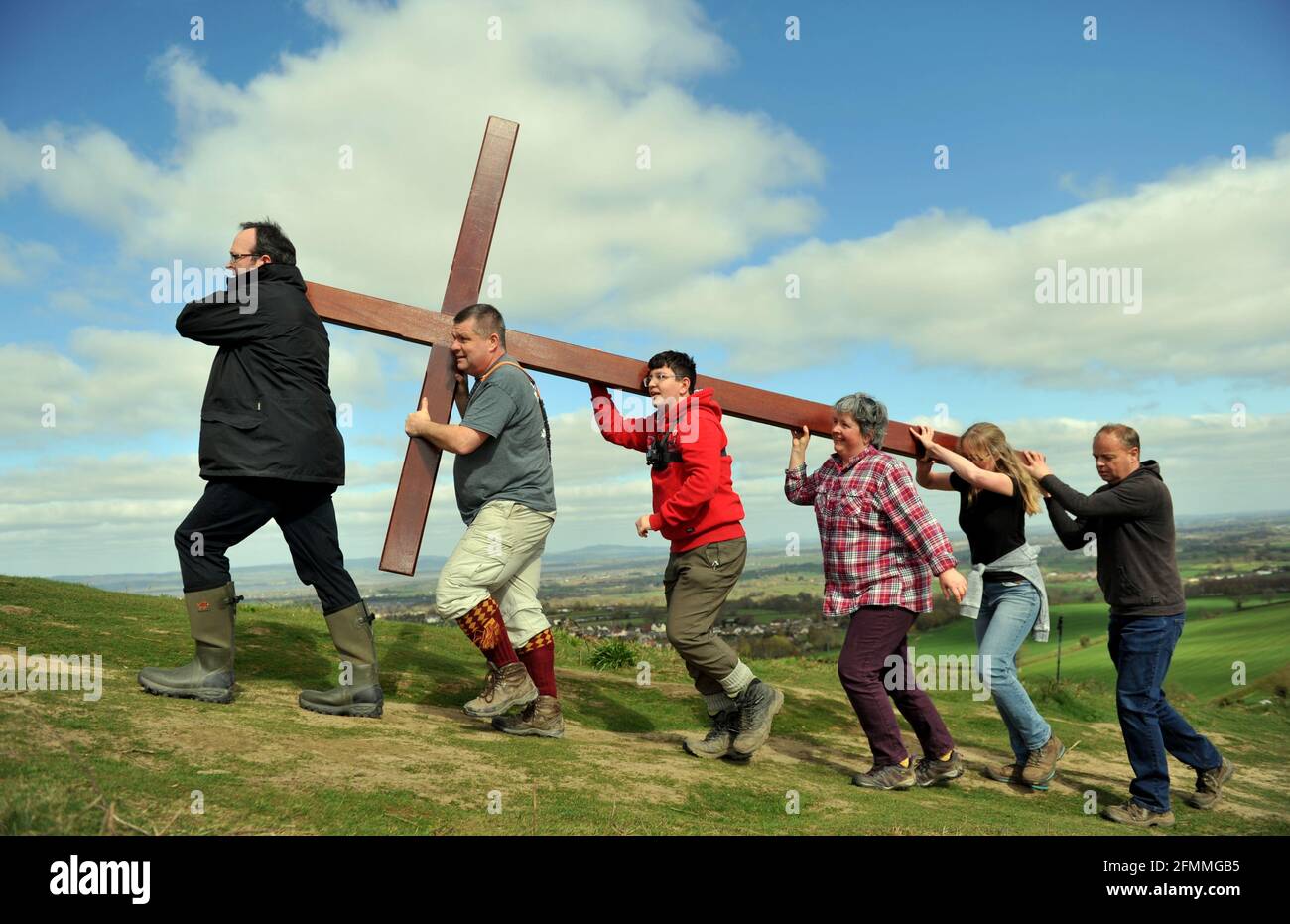 Am Karfreitag vor dem Ostersonntag ein Holzkreuz auf den Cam Peak tragen, bei einem Spaziergang von Witness, Gloucestershire Stockfoto