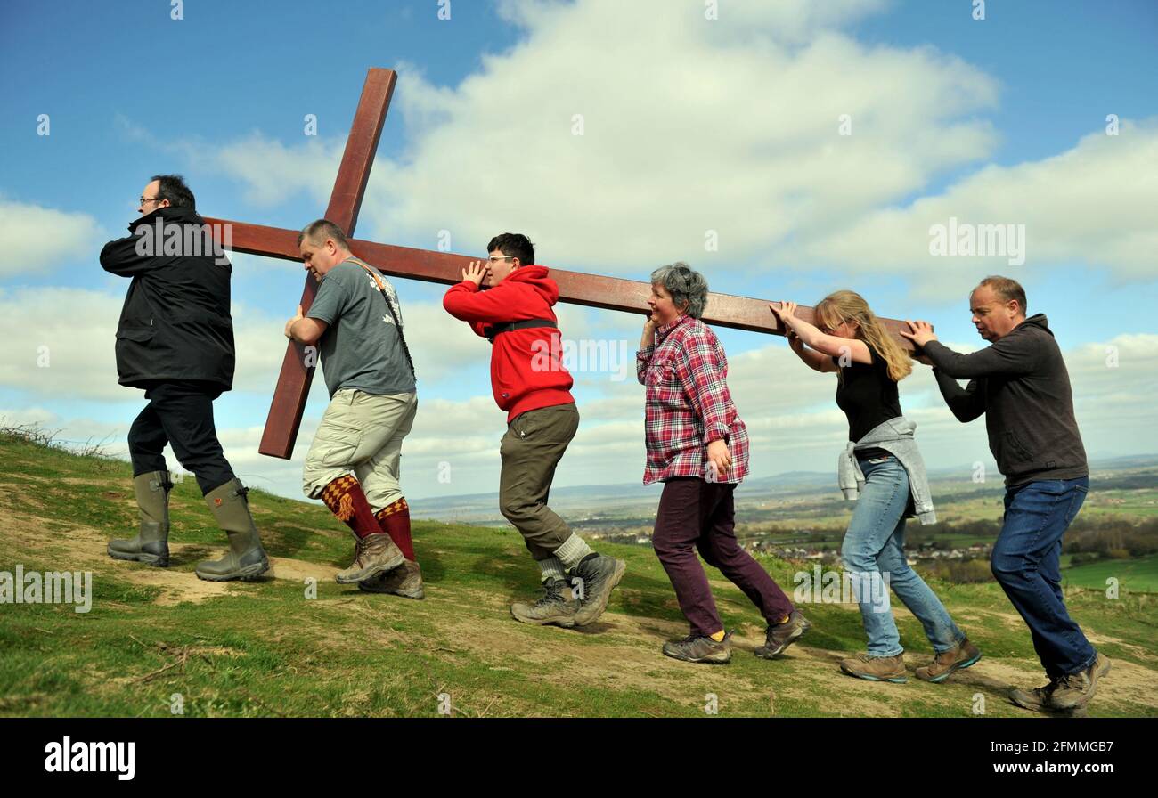 Am Karfreitag vor dem Ostersonntag ein Holzkreuz auf den Cam Peak tragen, bei einem Spaziergang von Witness, Gloucestershire Stockfoto