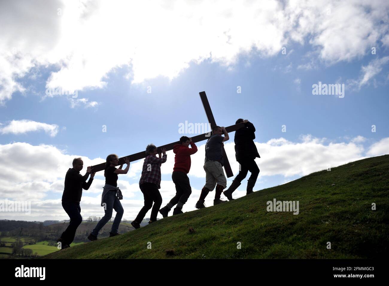 Am Karfreitag vor dem Ostersonntag ein Holzkreuz auf den Cam Peak tragen, bei einem Spaziergang von Witness, Gloucestershire Stockfoto