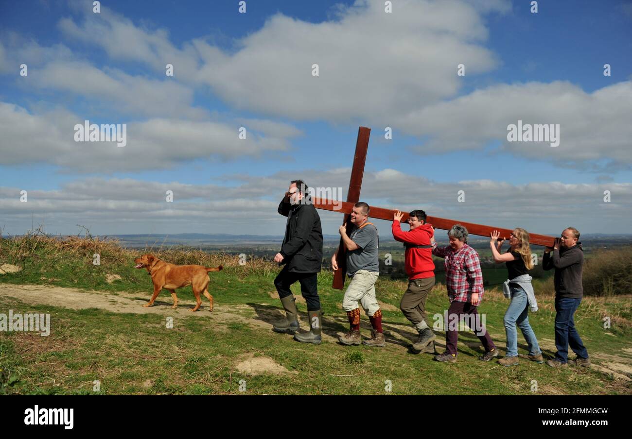 Am Karfreitag vor dem Ostersonntag ein Holzkreuz auf den Cam Peak tragen, bei einem Spaziergang von Witness, Gloucestershire Stockfoto