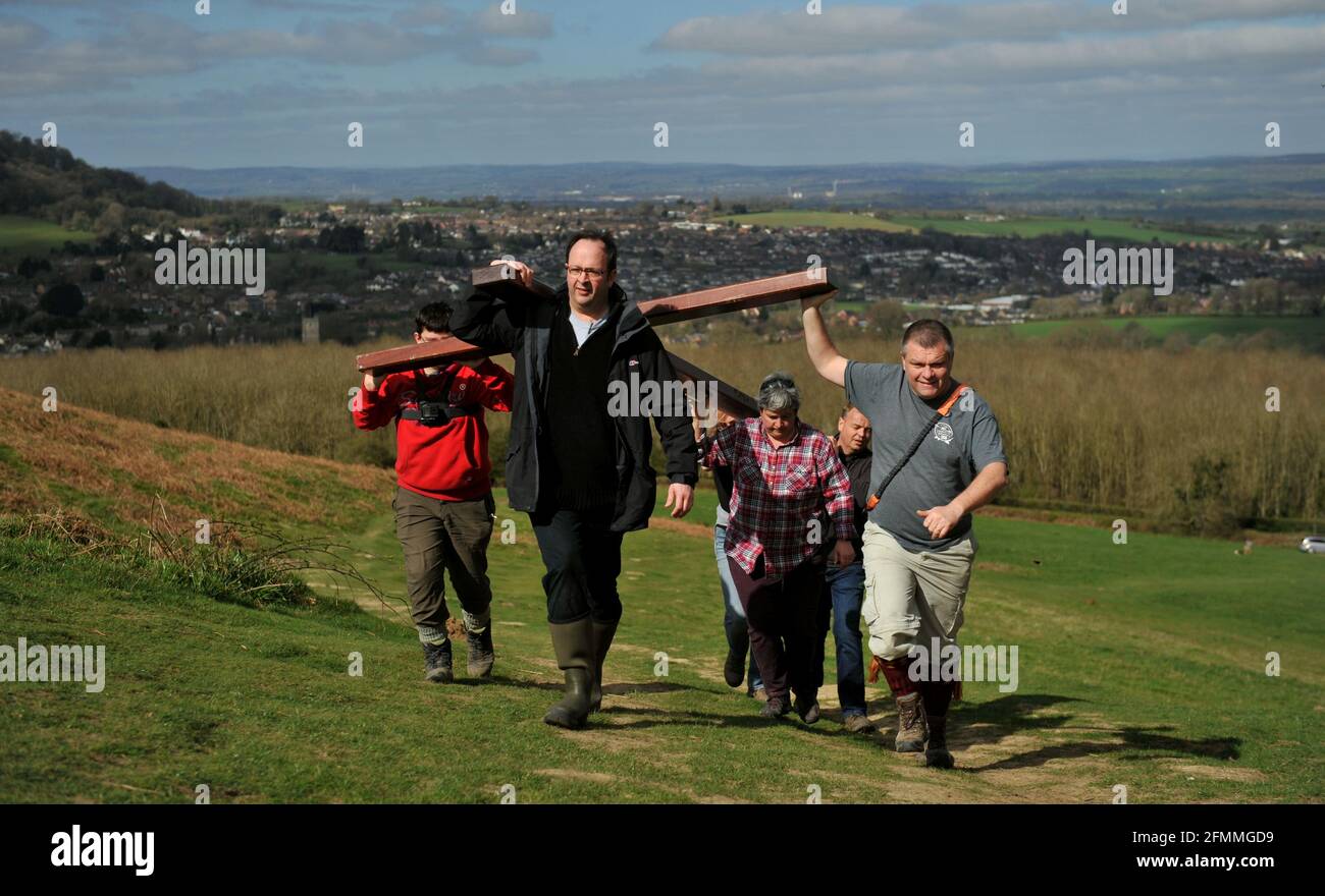 Am Karfreitag vor dem Ostersonntag ein Holzkreuz auf den Cam Peak tragen, bei einem Spaziergang von Witness, Gloucestershire Stockfoto