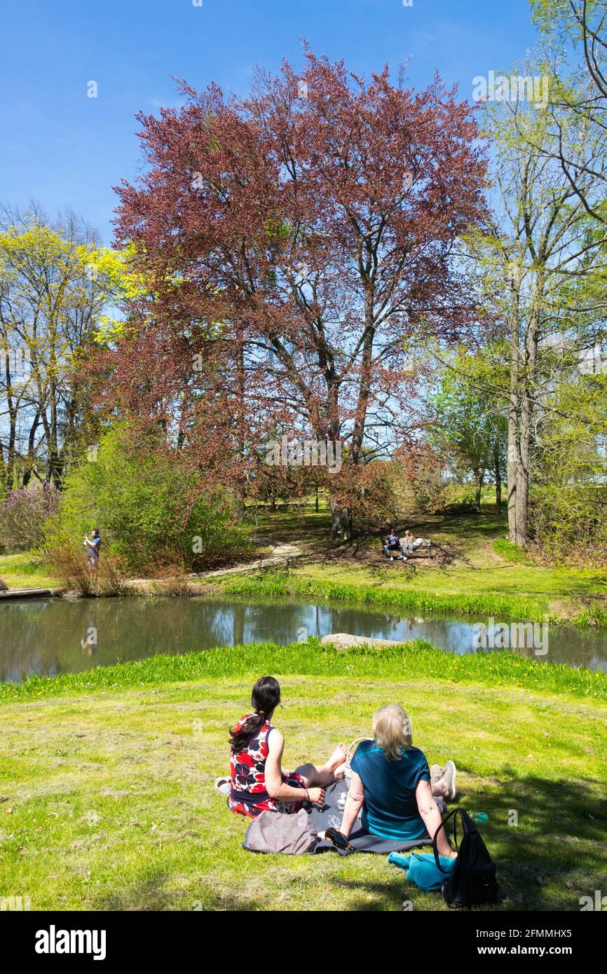 Zwei Frauen, die sich im Frühlingspark ausruhen und schönes Wetter und Lifestyle genießen Stockfoto