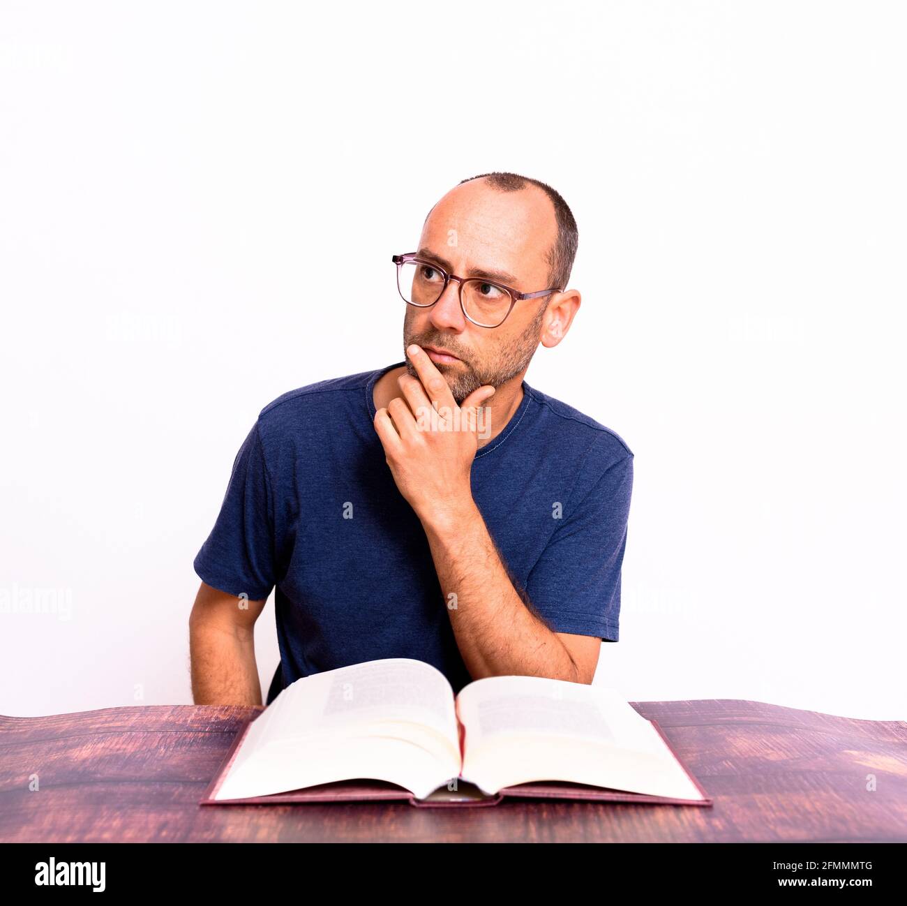 Der Mensch liest ein Buch konzentriert und Ausdruck auf seinem Gesicht, isoliert auf weißem Hintergrund. Stockfoto