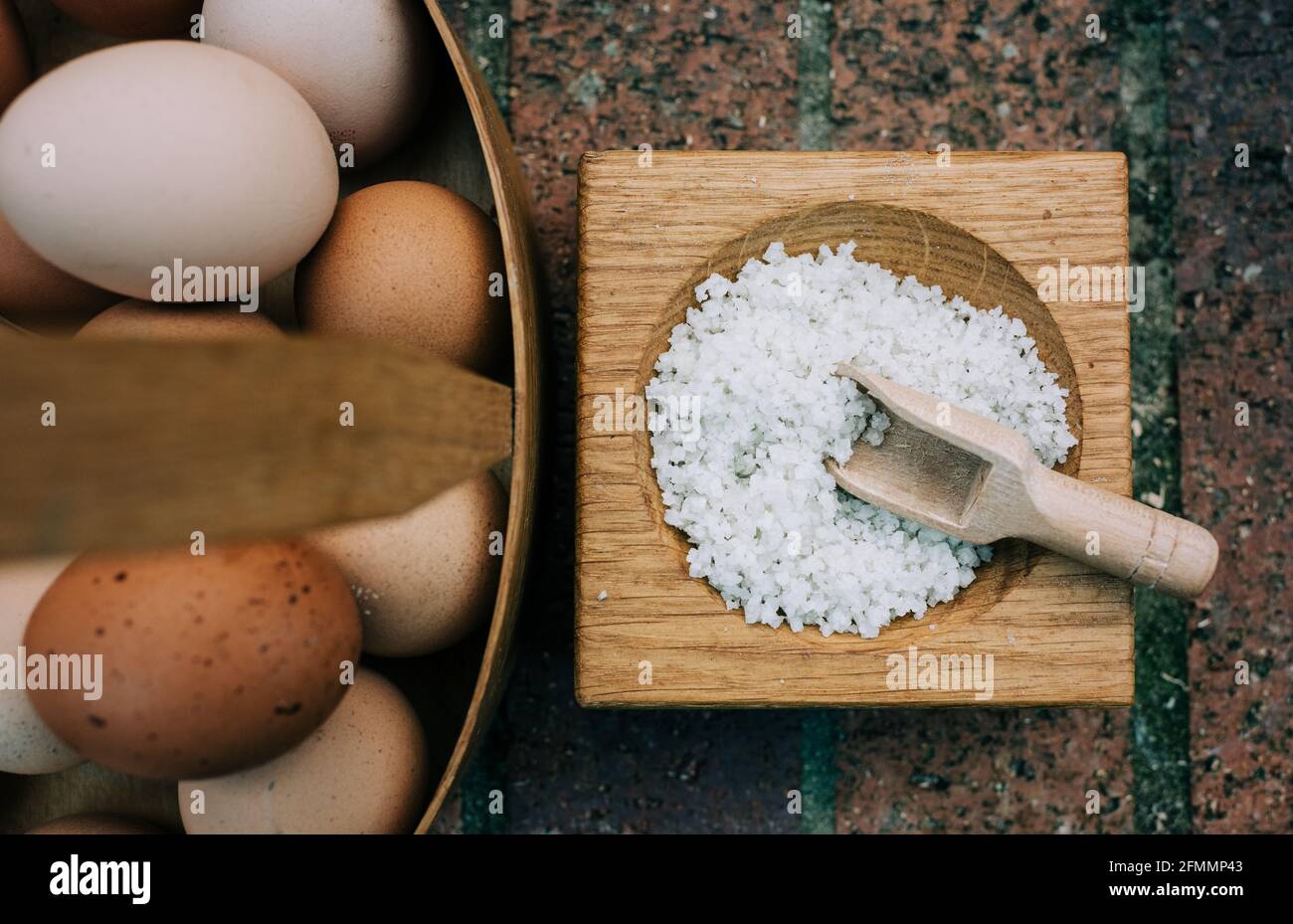 Salz und frische gemischte Eier in einem Korb auf einem Backsteinmauer draußen Stockfoto