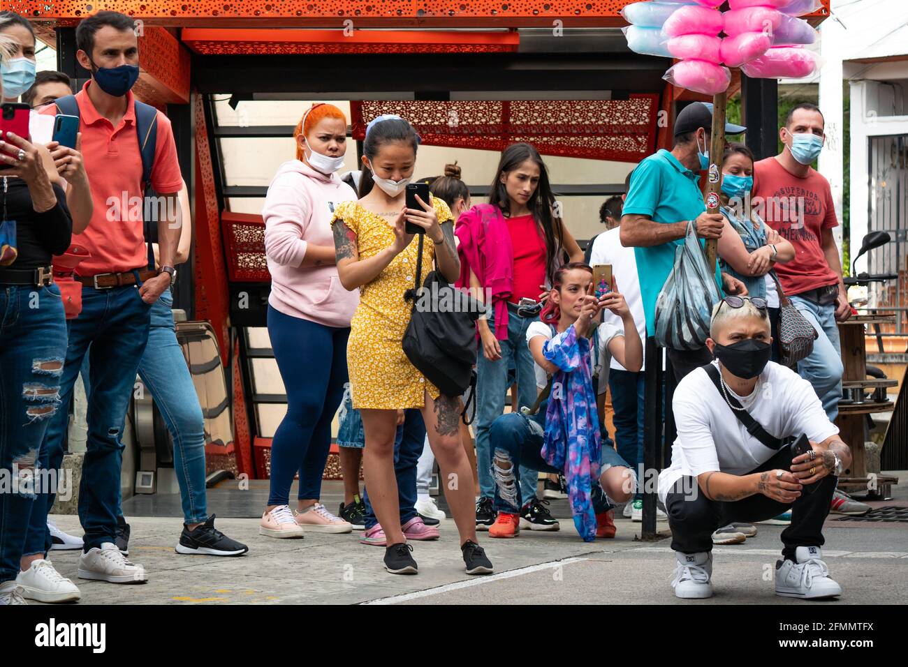 Medellin, Antioquia, Kolumbien - März 27 2021: Junge asiatische Frau macht Bilder in der Mitte einer Gruppe von Lateinerinnen, die den Tanz schauen Stockfoto