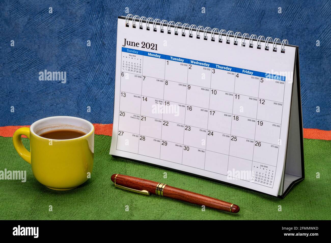 Juni 2021 - Spirale Desktop-Kalender gegen abstrakte Papierlandschaft mit einer Tasse Kaffee, Zeit und Geschäftskonzept Stockfoto