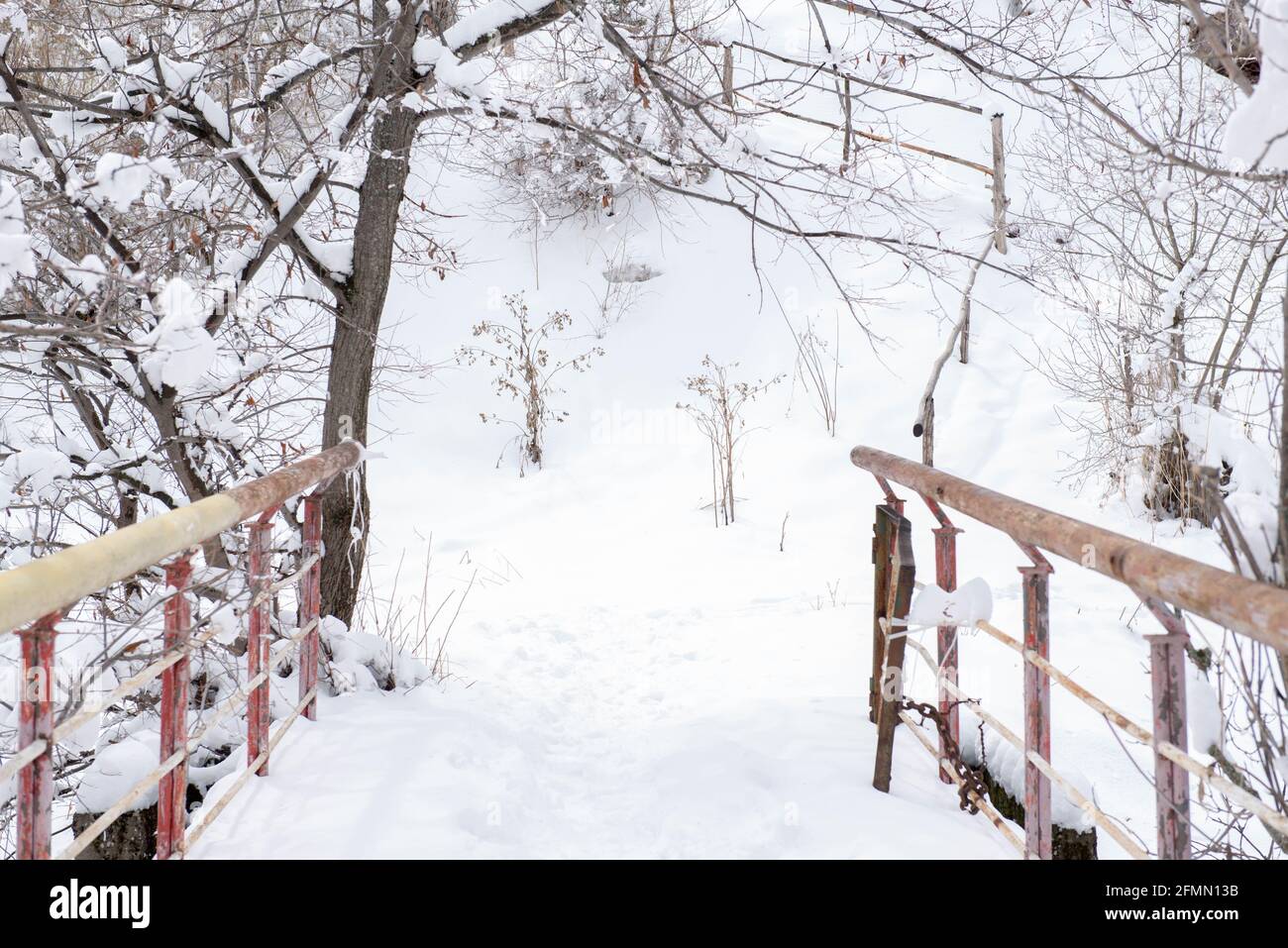 Fragment einer Brücke im Schnee über den Fluss Stockfoto