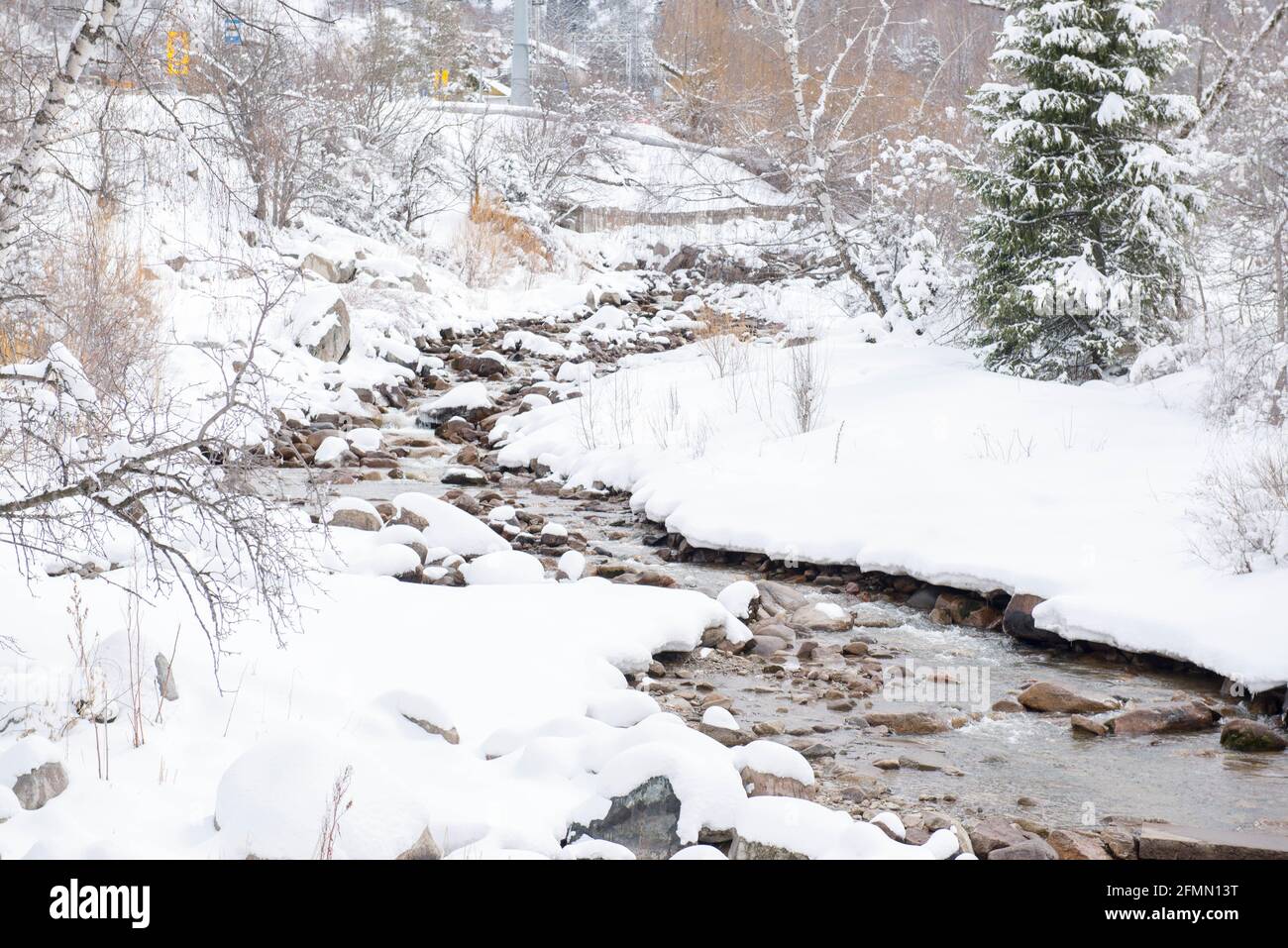 Im Winterwald ist der Fluss kalt im Schnee Stockfoto