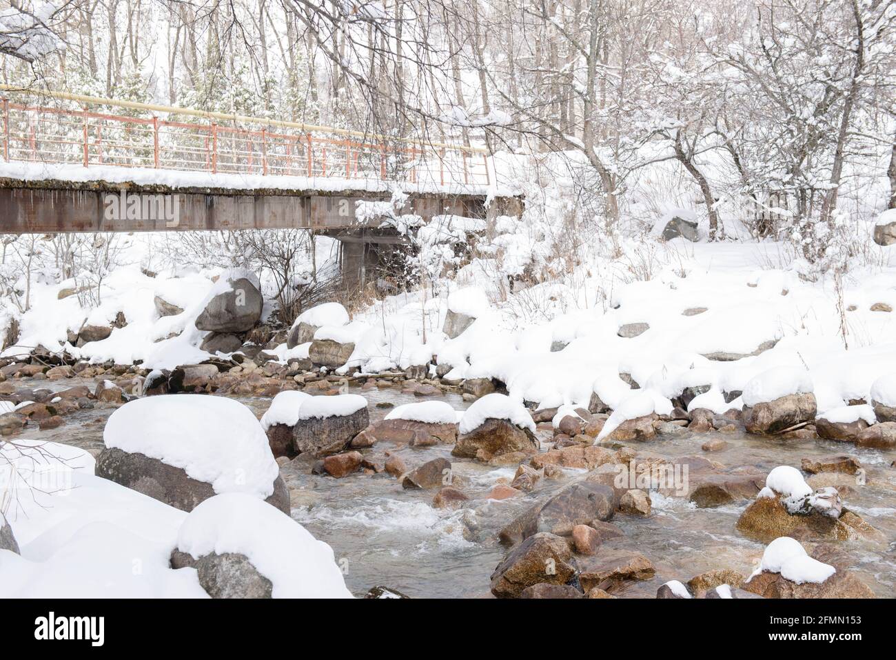 Schneebrücke über einen Bergfluss im Winter Stockfoto