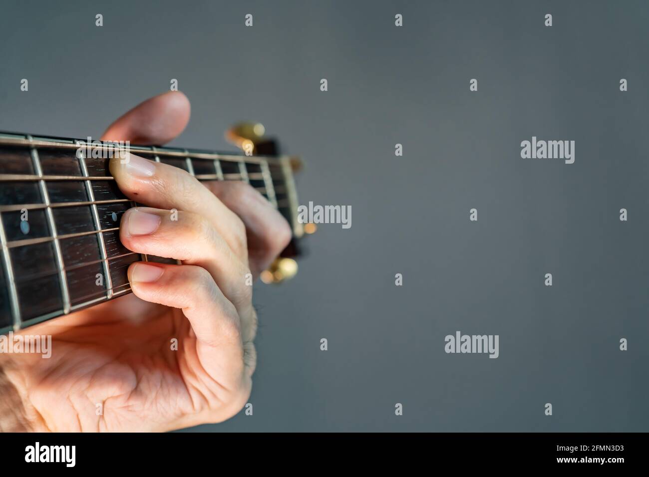 Hand hält Gitarrenakkord mit Kopierraum auf der rechten Seite Stockfoto