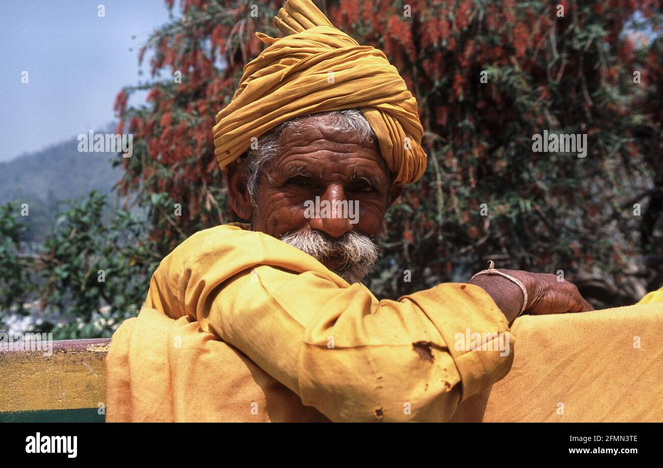 20.03.2010, Rishikesh, Uttarakhand, Indien, Asien - EIN bärtiger Mann mit Turban posiert für ein Foto auf einer Bank. Stockfoto