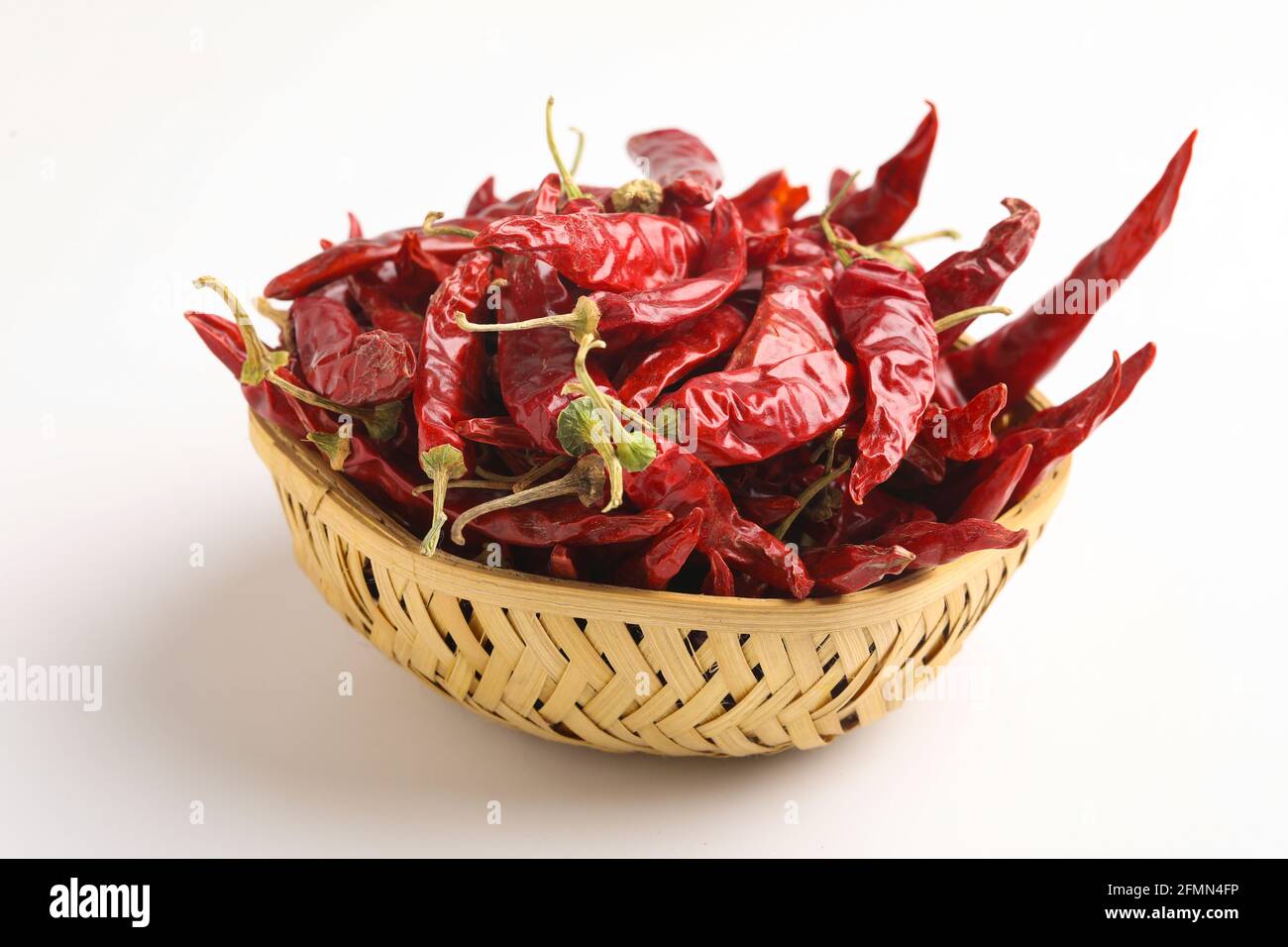 Getrocknete rote Chilischote und rotes Chilipulver in einer Glasschüssel Und Holzlöffel auf weißem Hintergrund Stockfoto