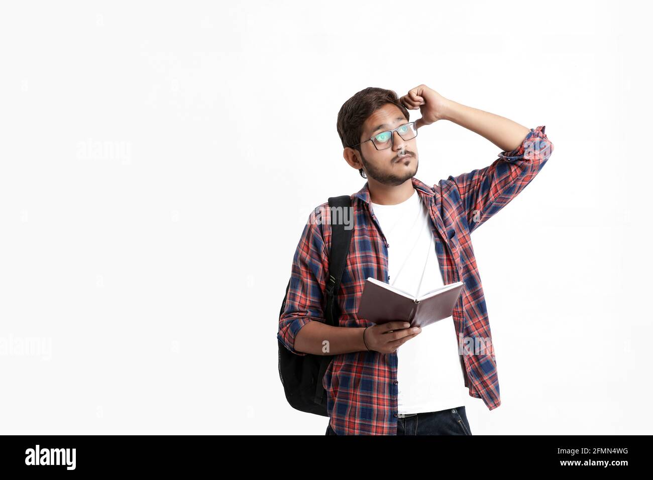 Junge gutaussehende indische College-Student geben Denken Ausdruck auf weiß Hintergrund Stockfoto