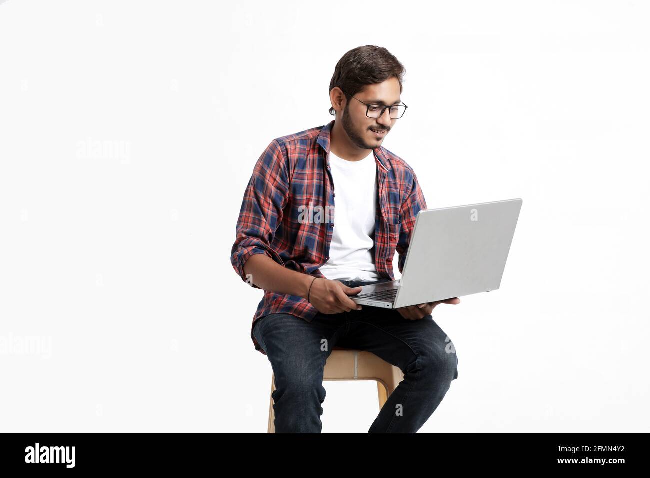 Indische College-Student mit Laptop auf weißem Hintergrund. Stockfoto