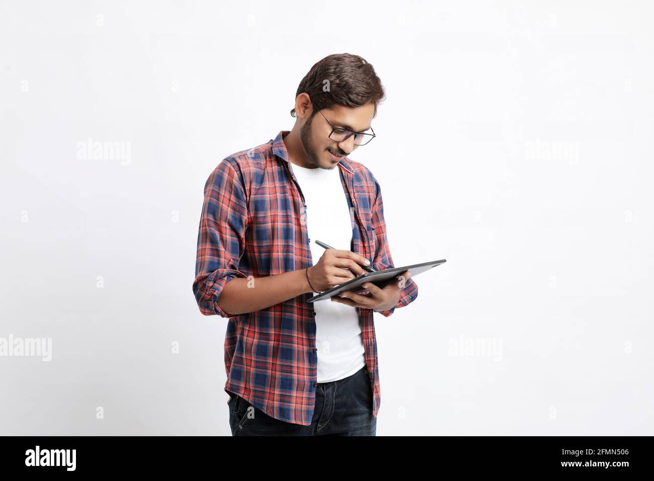 Indian Professional Designer mit Grafik-Tablet mit Smartphone mit digitalem Stift verbunden. Stockfoto