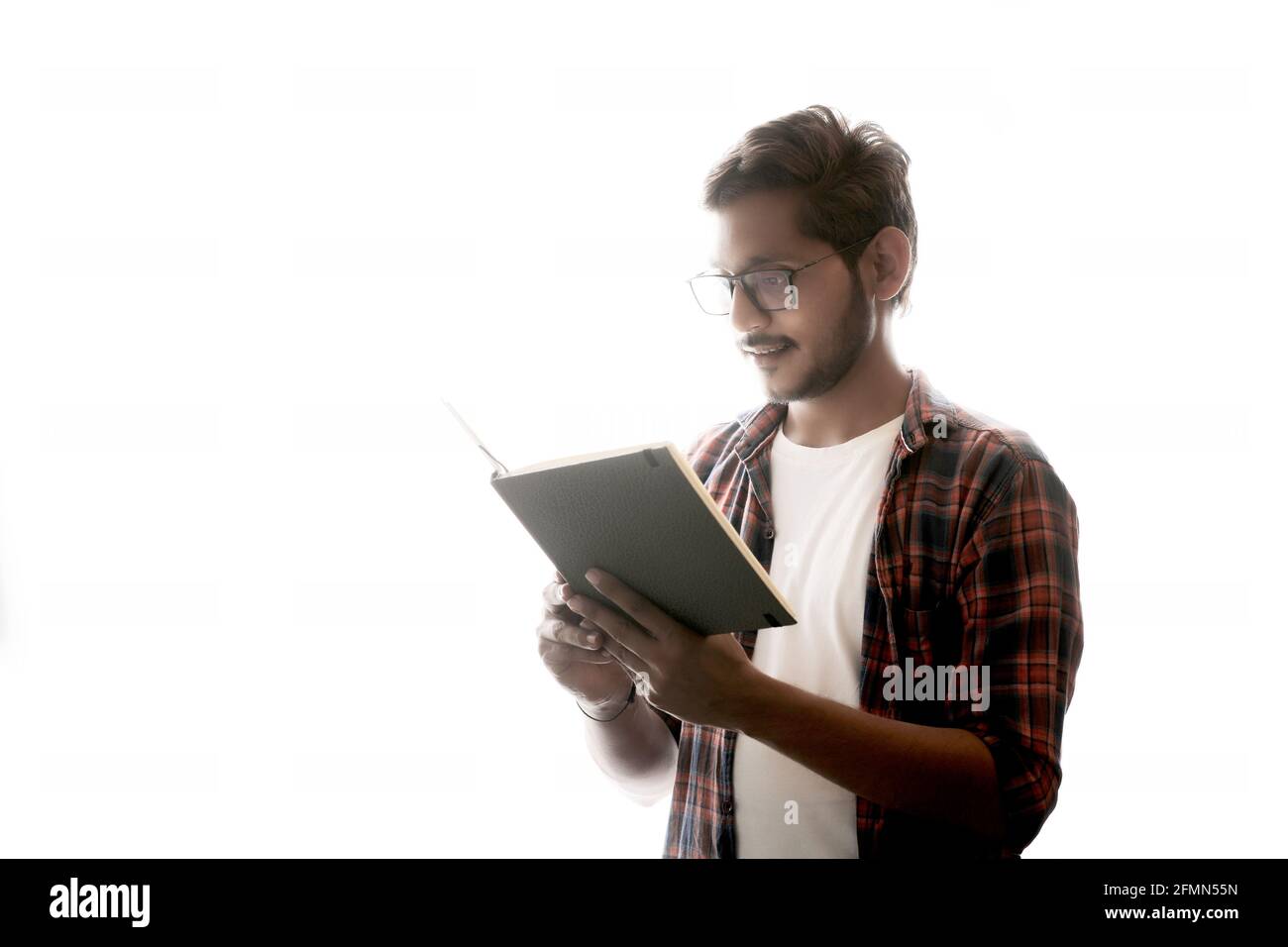 Indische College-Student Buch auf weißem Hintergrund zu lesen. Stockfoto
