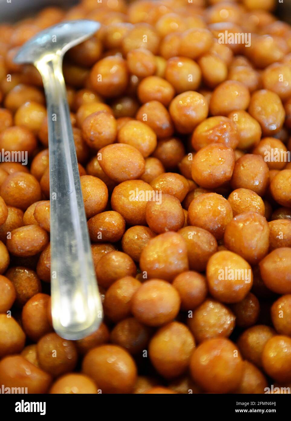 Lumet il Adi, bekannt als Awwameh im Grunde Teig Puffs, die gebraten werden ist, entwässert und dann in Zuckersirup getränkt. Stockfoto