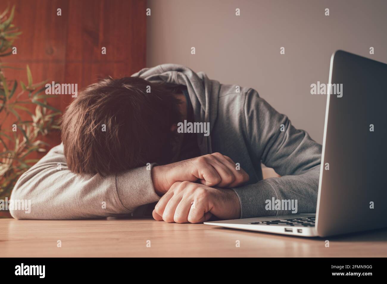 Müder freiberuflicher Mitarbeiter schläft am Schreibtisch des Heimbüros, Nahaufnahme mit selektivem Fokus Stockfoto