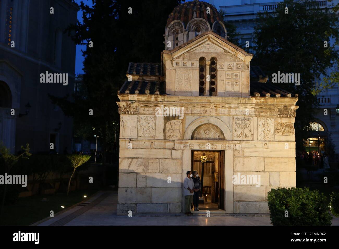 Griechisch-orthodoxe Priester halten während der Karfreitagsprozession des Epitaphios in der Kathedrale von Athen die Bahre hoch, die die Vorbereitung Christi auf die Beerdigung darstellt. Die Kirchen waren letzte Ostern geschlossen, dürfen aber für die diesjährigen Gottesdienste geöffnet bleiben, mit Sitzbeschränkungen und obligatorischer Verwendung von COVID-19-Testkits für Priester und Kirchenpersonal. Der Hauptgottesdienst am kommenden Samstag wird drei Stunden früher statt, um 9:00 Uhr aufgrund von Sperrmaßnahmen, während die Gläubigen werden von der Regierung geraten, im Freien zu bleiben. Stockfoto