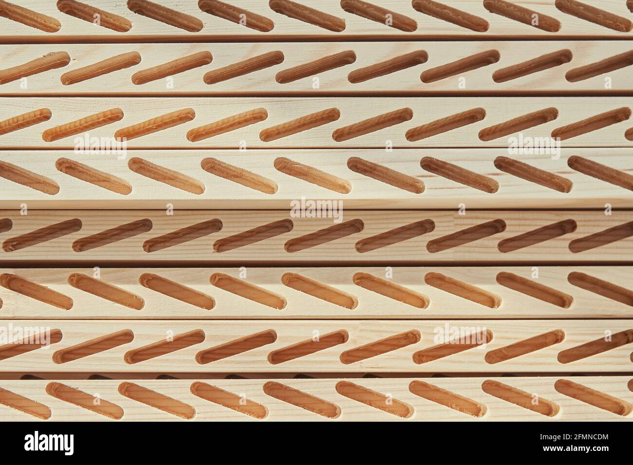 Satz von Holzstangen mit Linien von geschnittenen Schlitzen zu Installieren Sie Planken für Jalousien in der hellen Schreinerei aus der Nähe Von oben Stockfoto