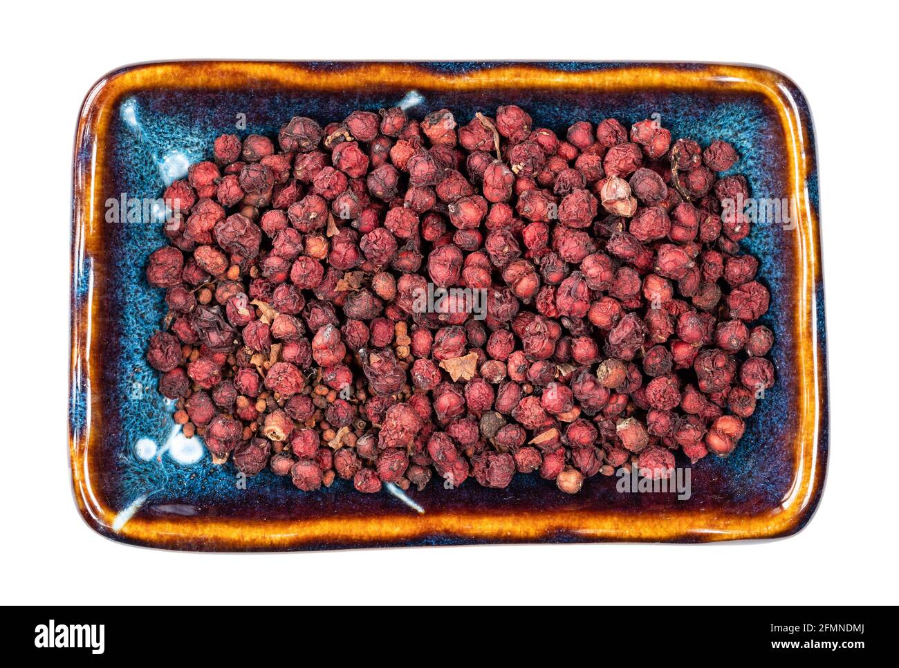 Draufsicht auf getrocknete Magnolienbeeren (Schisandra Chinensis Samen) In Keramikschale Ausschnitt auf weißem Hintergrund Stockfoto