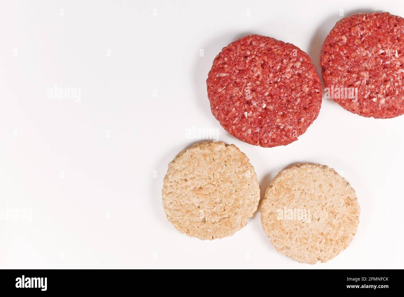 Vergleich von veganem Soja-Burger-Patty und echtem Fleisch patty Stockfoto