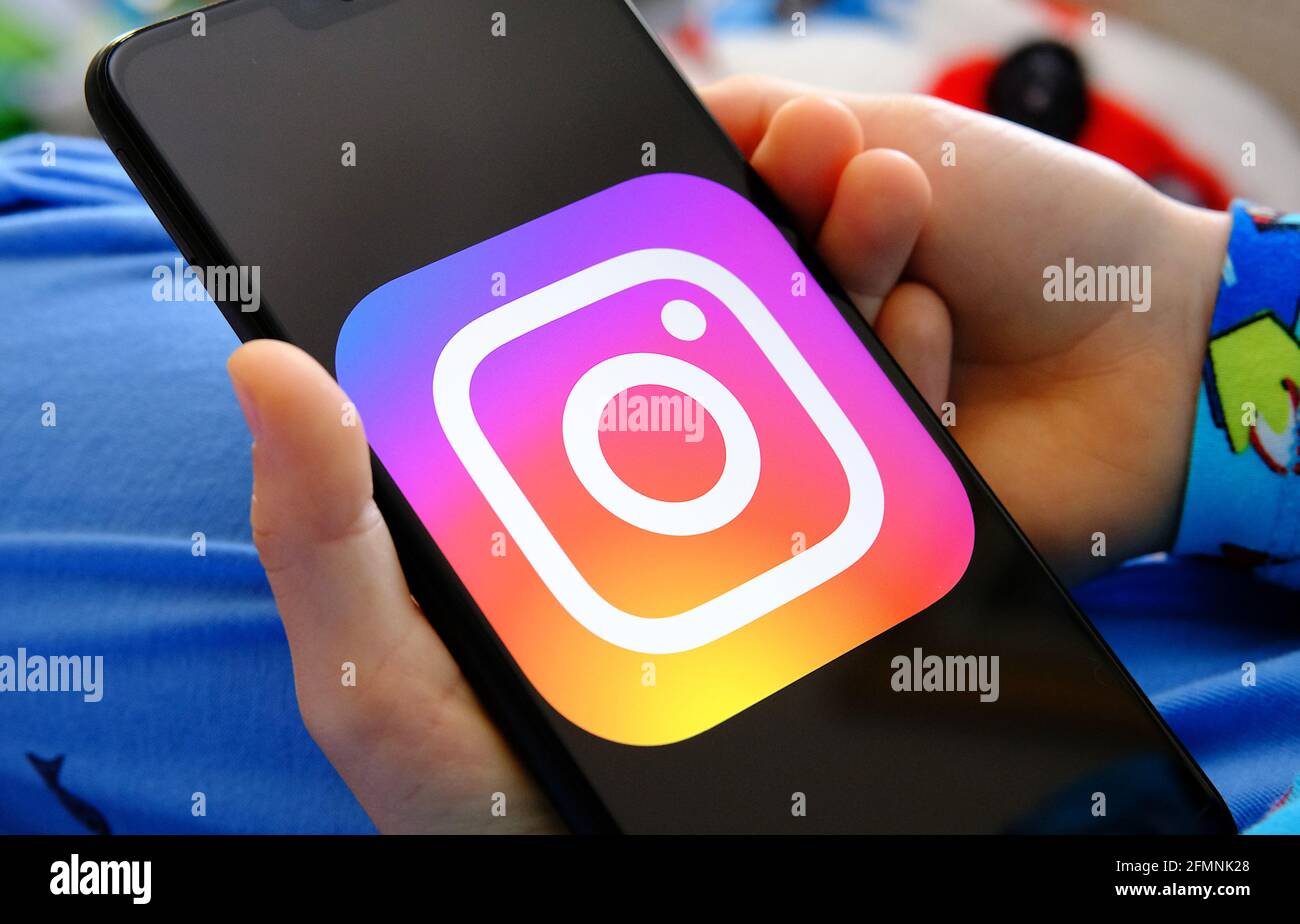 Kind hält Gerät mit instagram-App in den Händen. Konzept für Kinderschutz und Datenschutz in sozialen Medien. Stafford, Großbritannien, Mai 11, Stockfoto