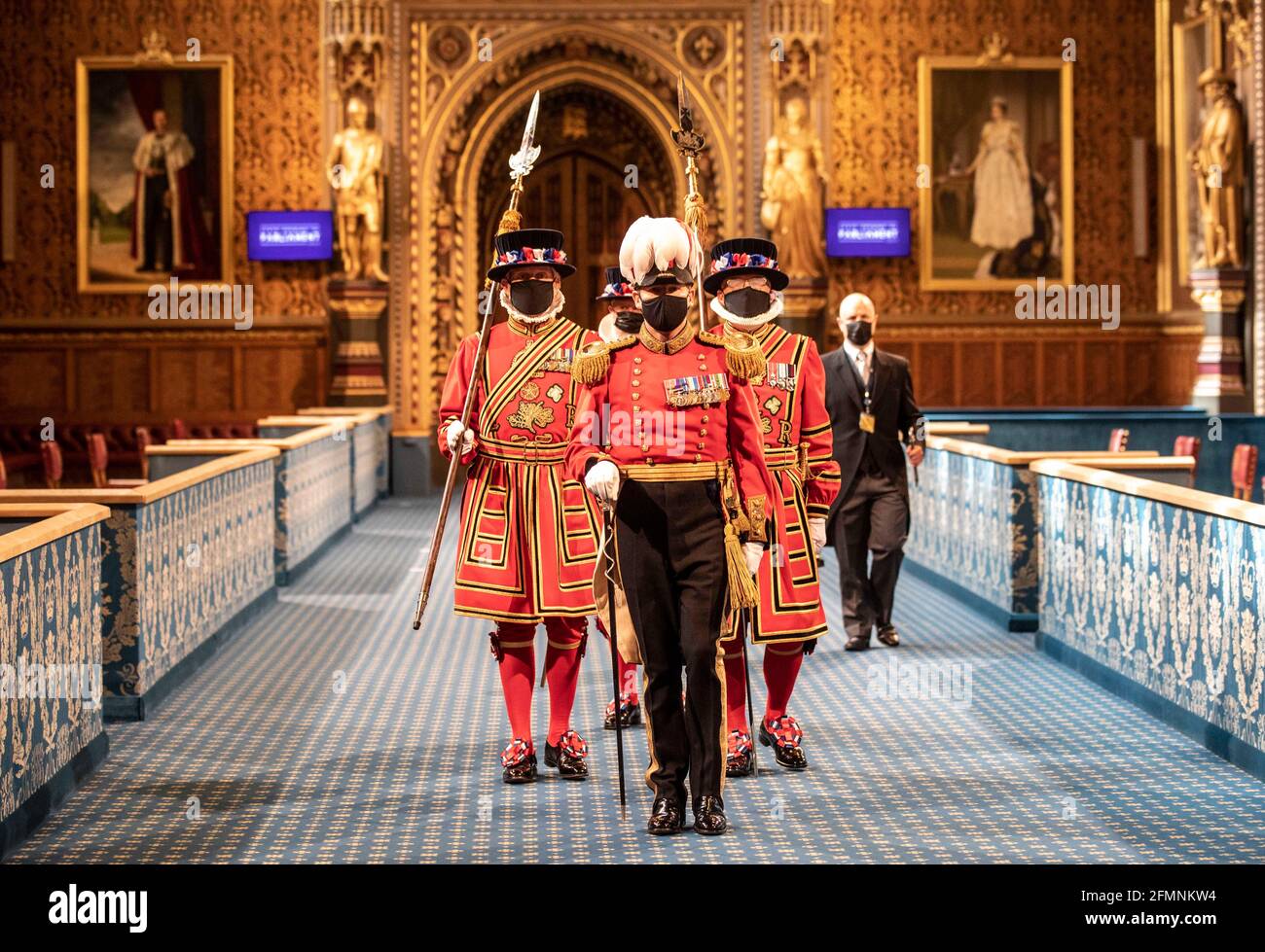 Maskierte Yeoman Warders marschieren entlang der Royal Gallery während der zeremoniellen Suche nach dem Palace of Westminster in London, vor der Staatseröffnung des Parlaments durch Königin Elizabeth II., im House of Lords. Bilddatum: Dienstag, 11. Mai 2021. Stockfoto