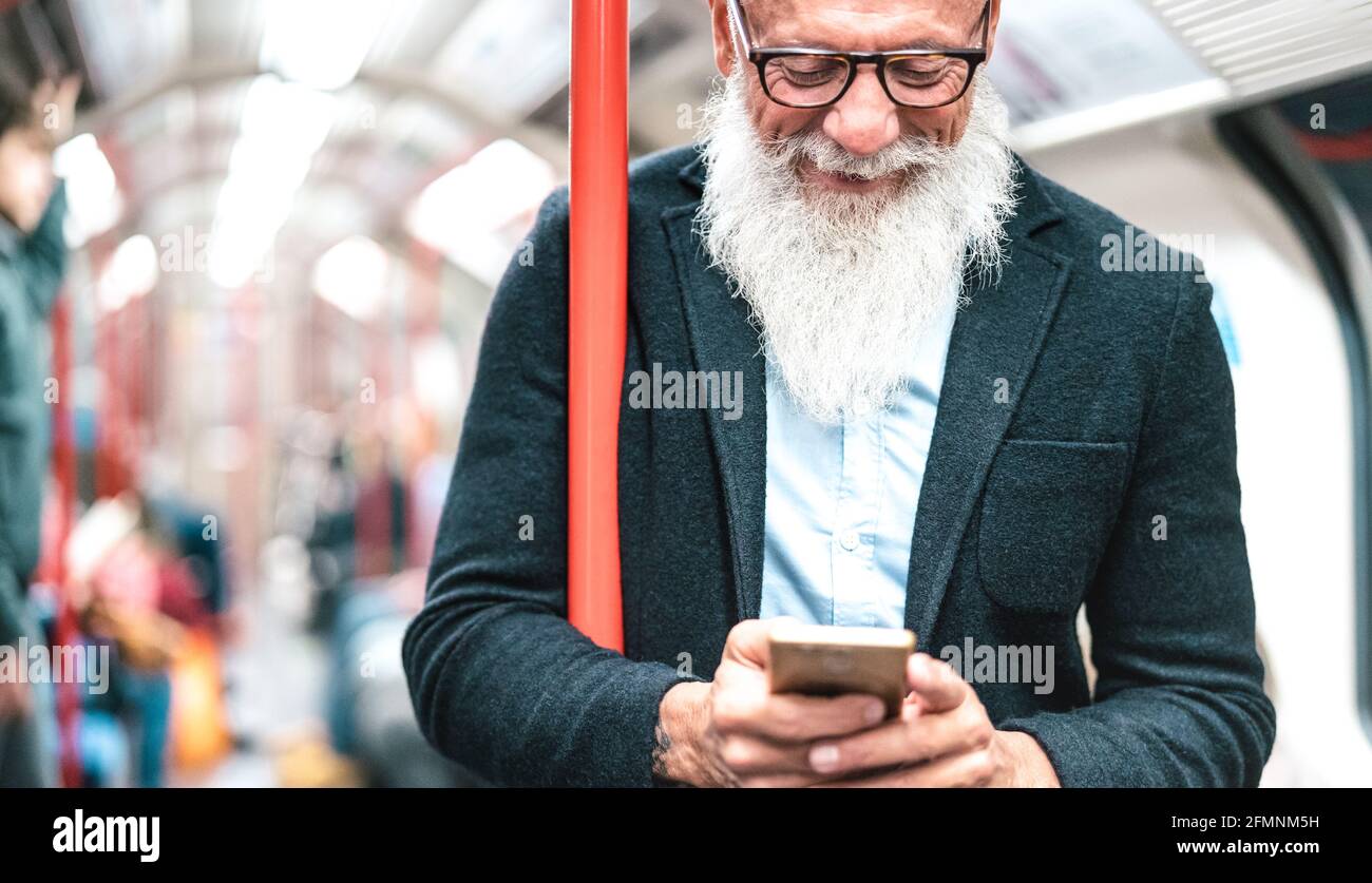 Hipster bärtiger Mann mit Handy in U-Bahn-Zug - trendige Erwachsene Person überprüfen Zeitplan mit Smartphone - glücklich Lifestyle und Technologie Stockfoto