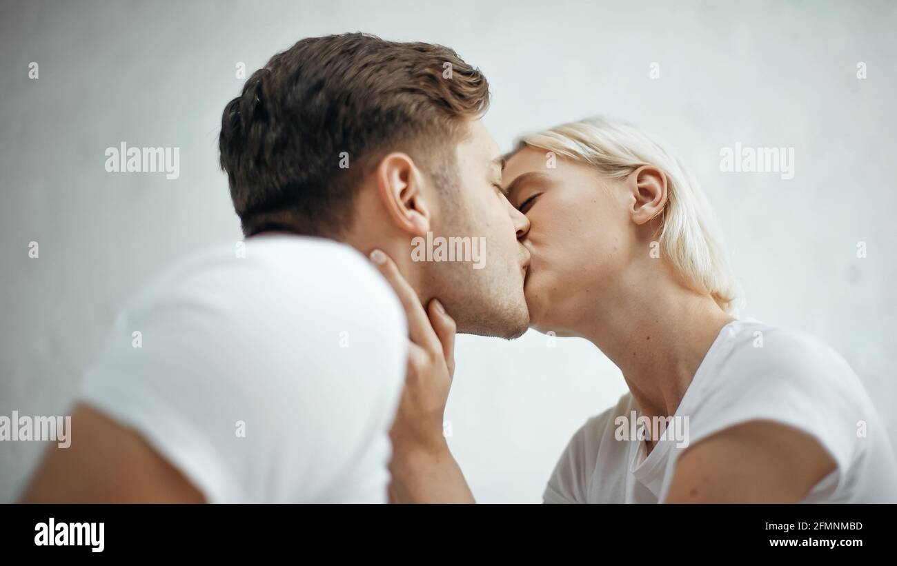 Junge blonde Frau küsst mit Freund Stockfoto