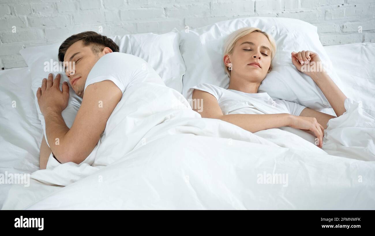 Junge Frau und Mann schlafen im Bett Stockfoto