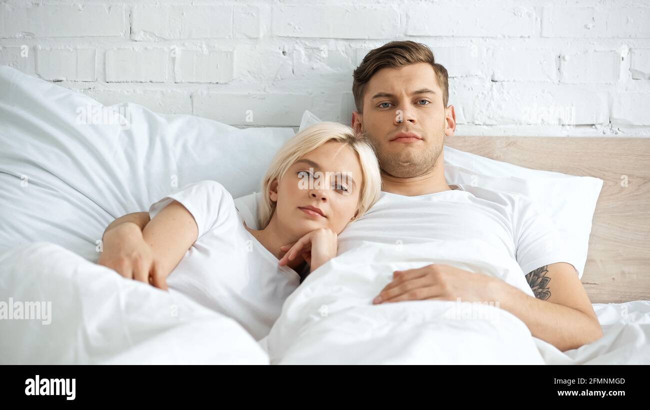 Tätowierte Mann im Bett mit blonden Freundin liegen Stockfoto