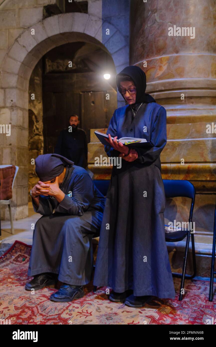 Jerusalem, Israel - 30. April 2021: Koptische Priester und Pilger beten am orthodoxen Karfreitag in der Grabeskirche in der Altstadt von Jerusalem, Israeli Stockfoto