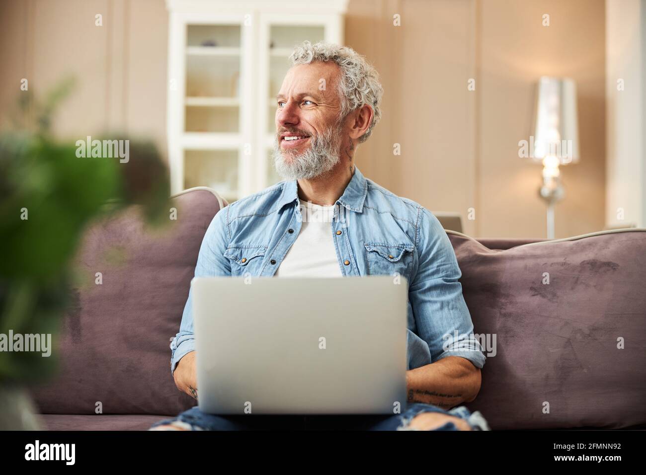 Fröhlicher bärtiger Mann, der tief in seinen Gedanken ist Stockfoto