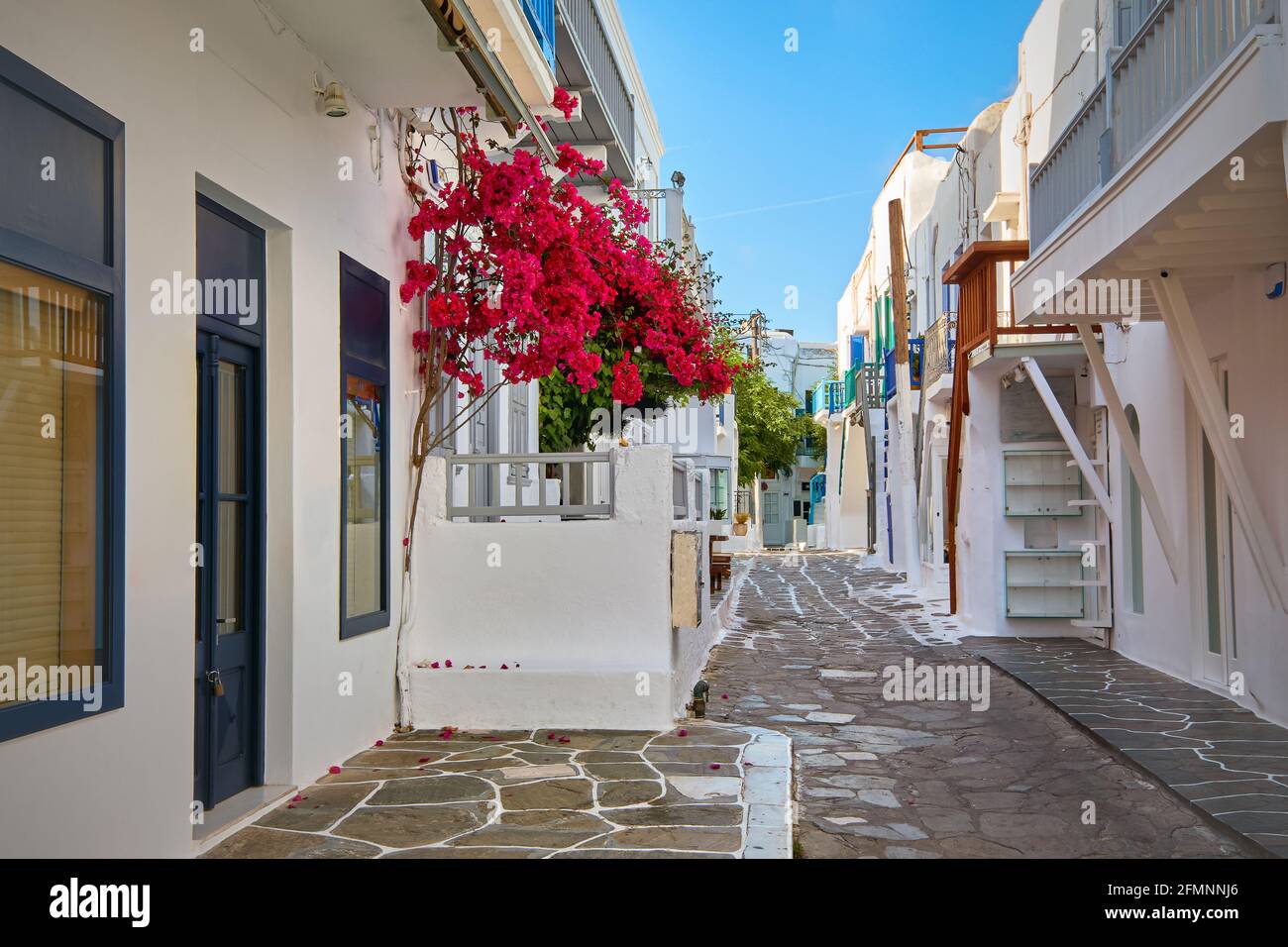 Schöne, traditionelle, enge Straßen griechischer Inselstädte. Weiß getünchte Häuser, Bougainvillea, Balkone, Treppen, Geschäfte, Cafés. Mykonos, Griechenland Stockfoto