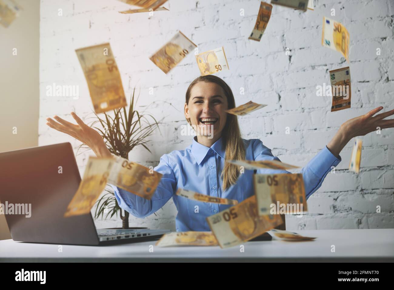 Erfolgreiche fröhliche Geschäftsfrau wirft Euro-Banknoten im Büro. Fallendes Geld Stockfoto