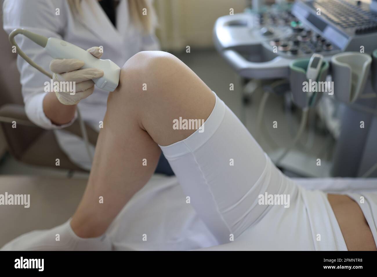 Arzt, der Ultraschalluntersuchung des Kniegelenks bei der Frau macht Nahaufnahme der Klinik Stockfoto