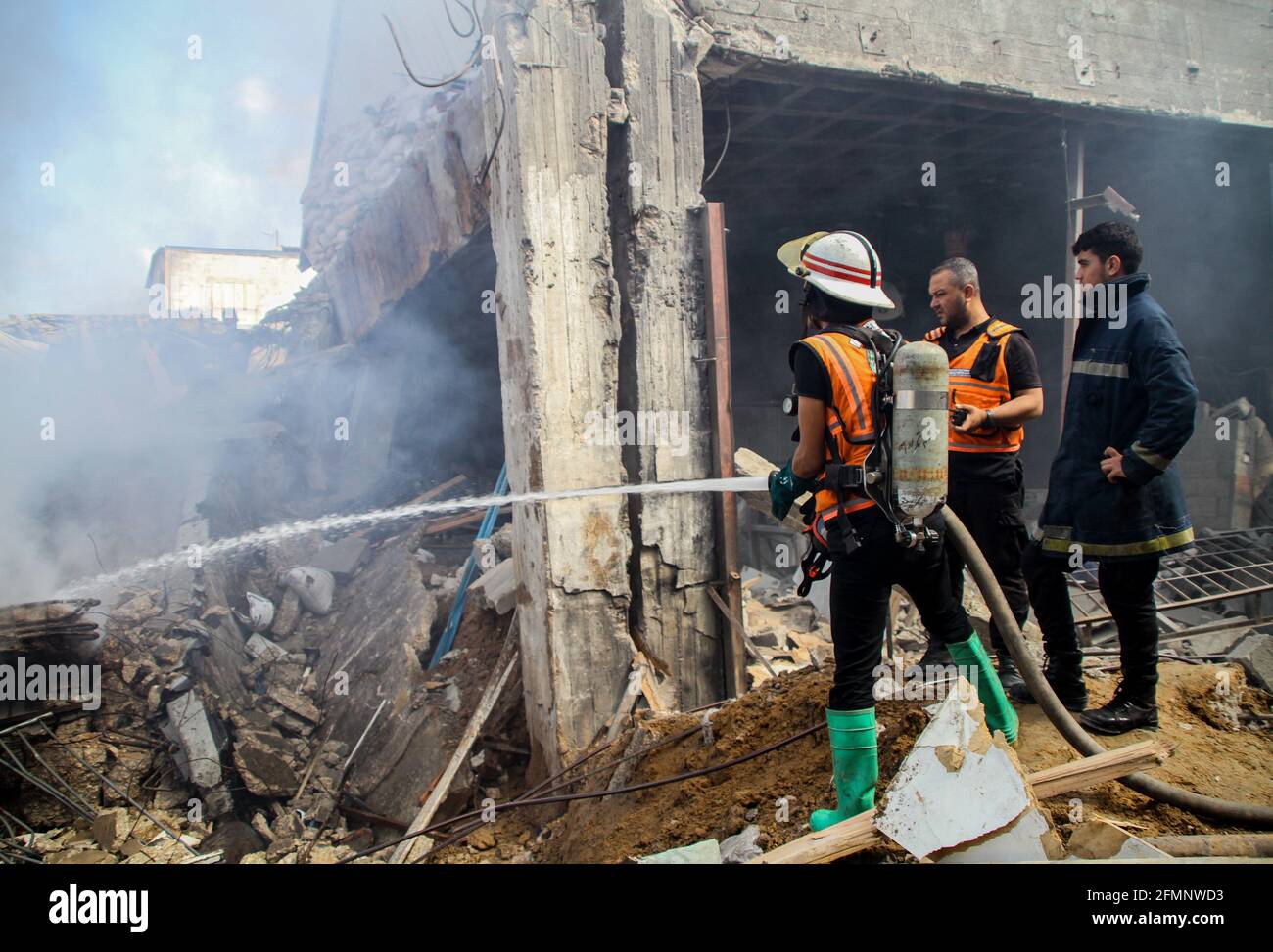 10. Mai 2021: Gaza, Palästina. 11 Mai 2021. Besatzungen der palästinensischen Zivilverteidigung inspizieren die von israelischen Jets getroffenen Industrieanlagen östlich des Flüchtlingslagers Jabalia im nördlichen Gazastreifen. Bei den israelischen Streiks am Montagabend und Dienstag früh am Morgen wurden mindestens 25 Palästinenser getötet, darunter 7 Kinder, und mehr als 100 verletzt. Israelische Razzien auf Gaza fanden als Vergeltung für den Raketenbeschuss aus Gaza auf Israel statt, der nach Angriffen der israelischen Polizei gegen palästinensische Gläubige auf die Al-Aqsa Moschee in den letzten Tagen und Zusammenstößen auf das Al-Aqsa-Kompou erfolgte Stockfoto